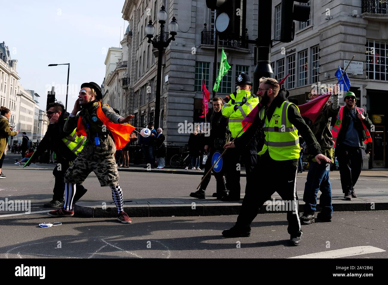 London, UK. Climate protesters with the Extinction Rebellion protest dance in front of a police officer at Piccadilly Circus. Stock Photo