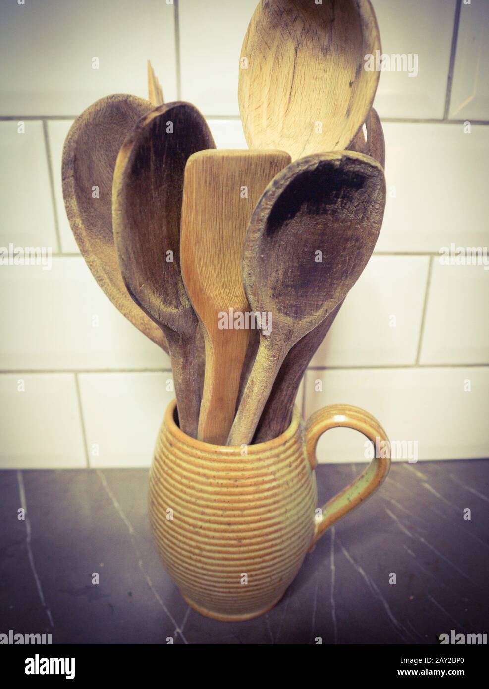 Wooden Kitchen Spoons in a coil pot jug on a marble top with white ...