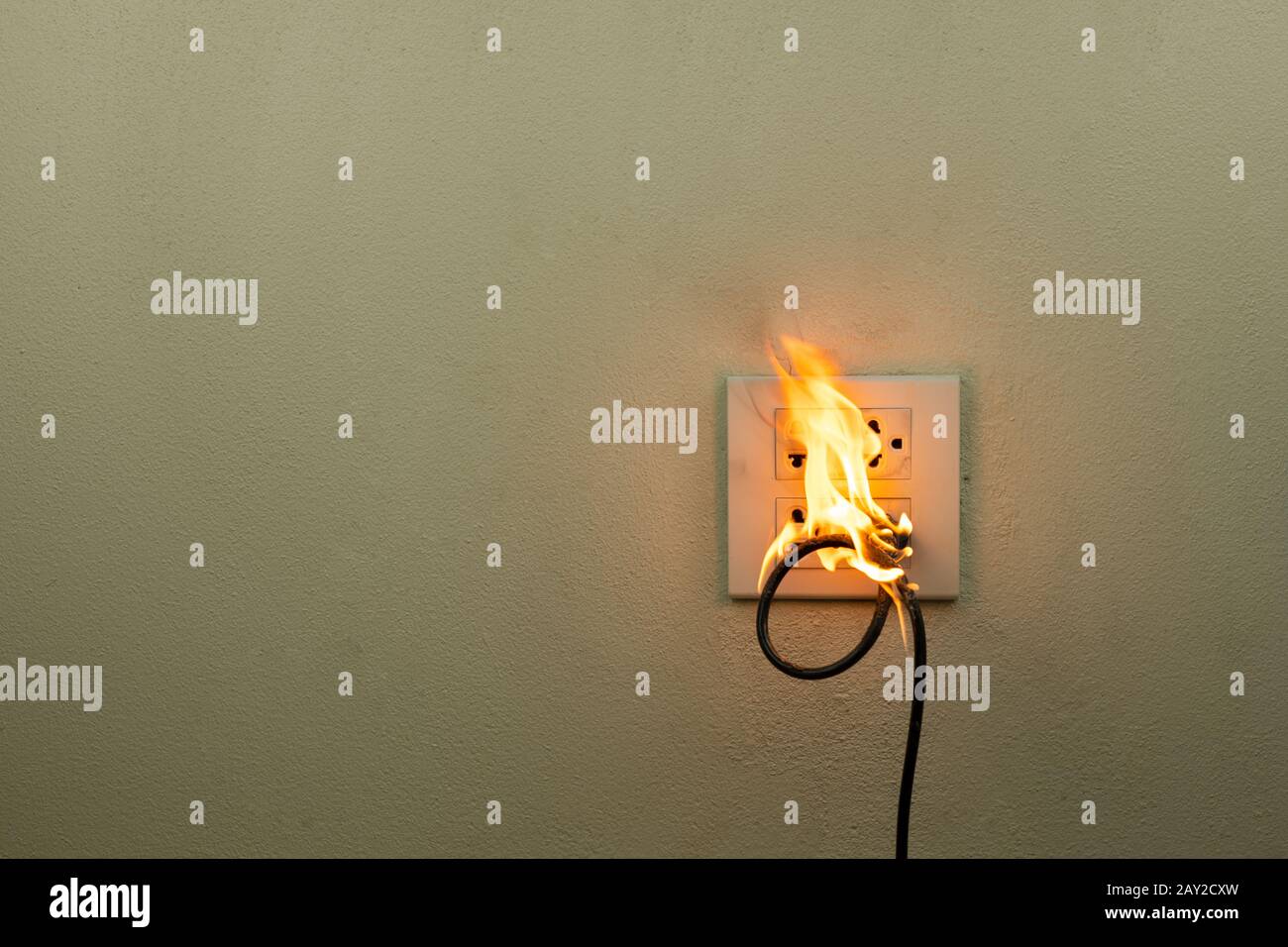 On fire electric wire plug in the receptacle at wall partition