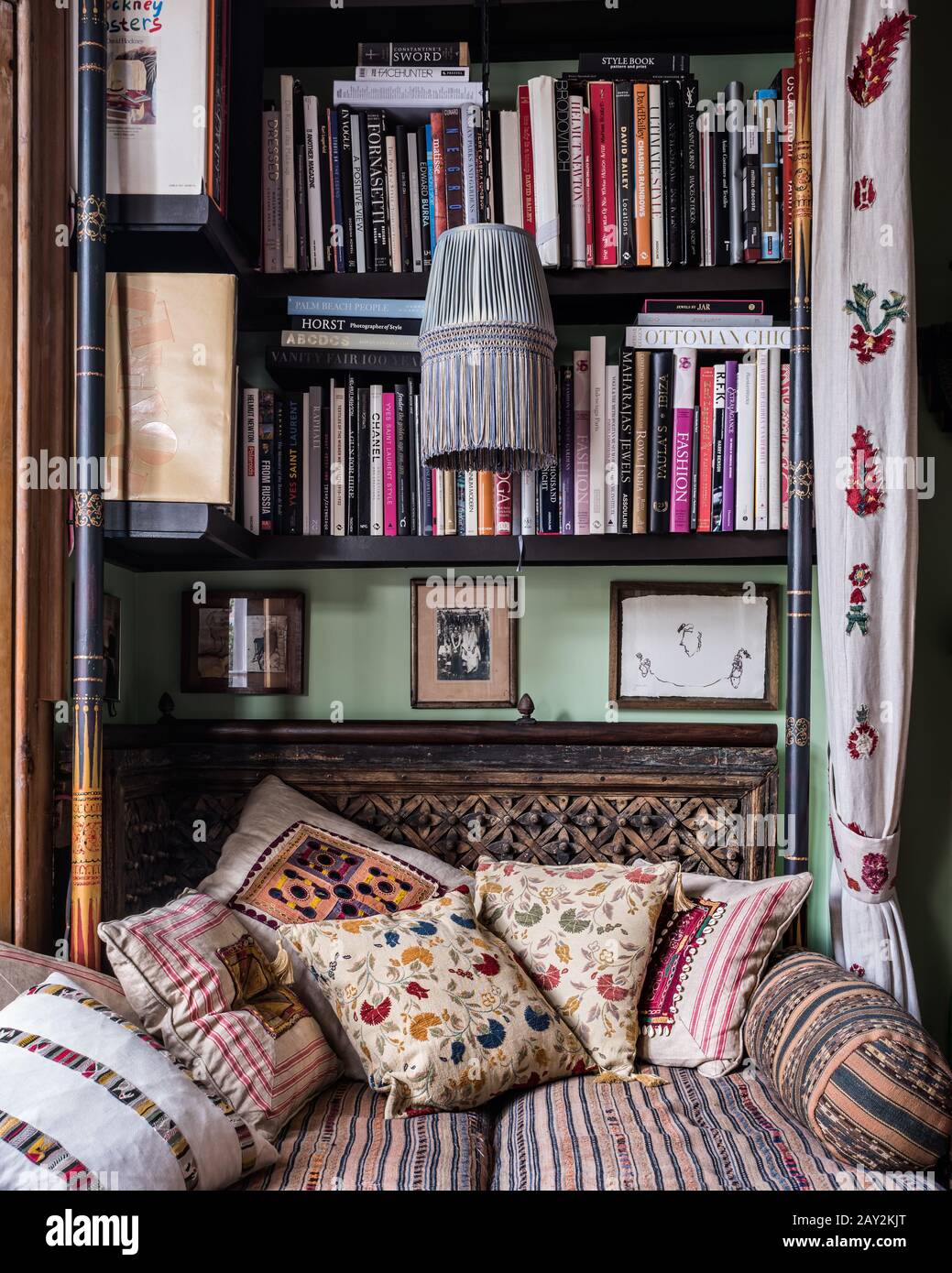 Bookshelf above patterned sofa Stock Photo Alamy