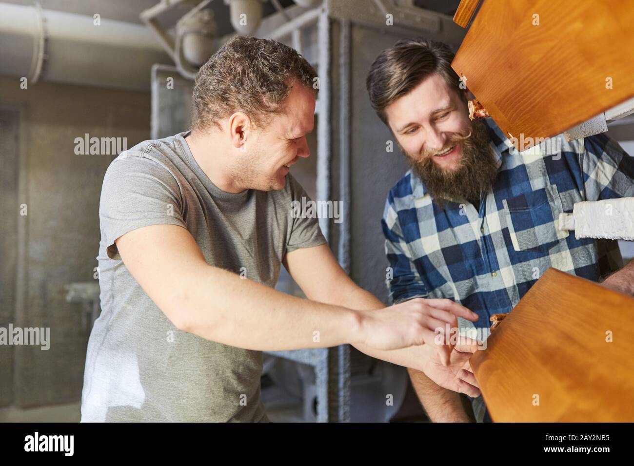 Carpenter apprentice and instructor check a wooden board in the carpentry Stock Photo