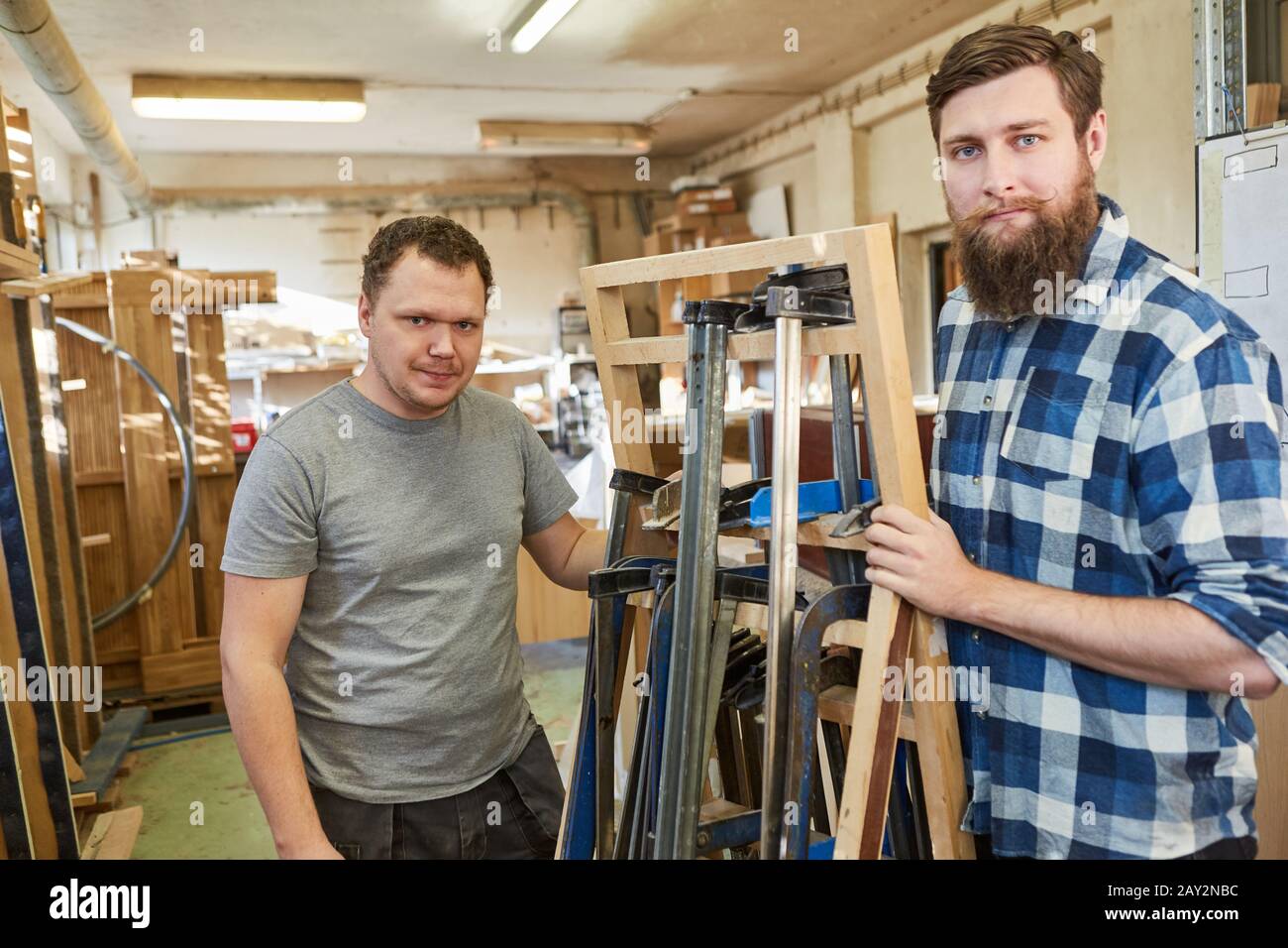 Two young carpenters or carpenters with a selection of screw clamps Stock Photo