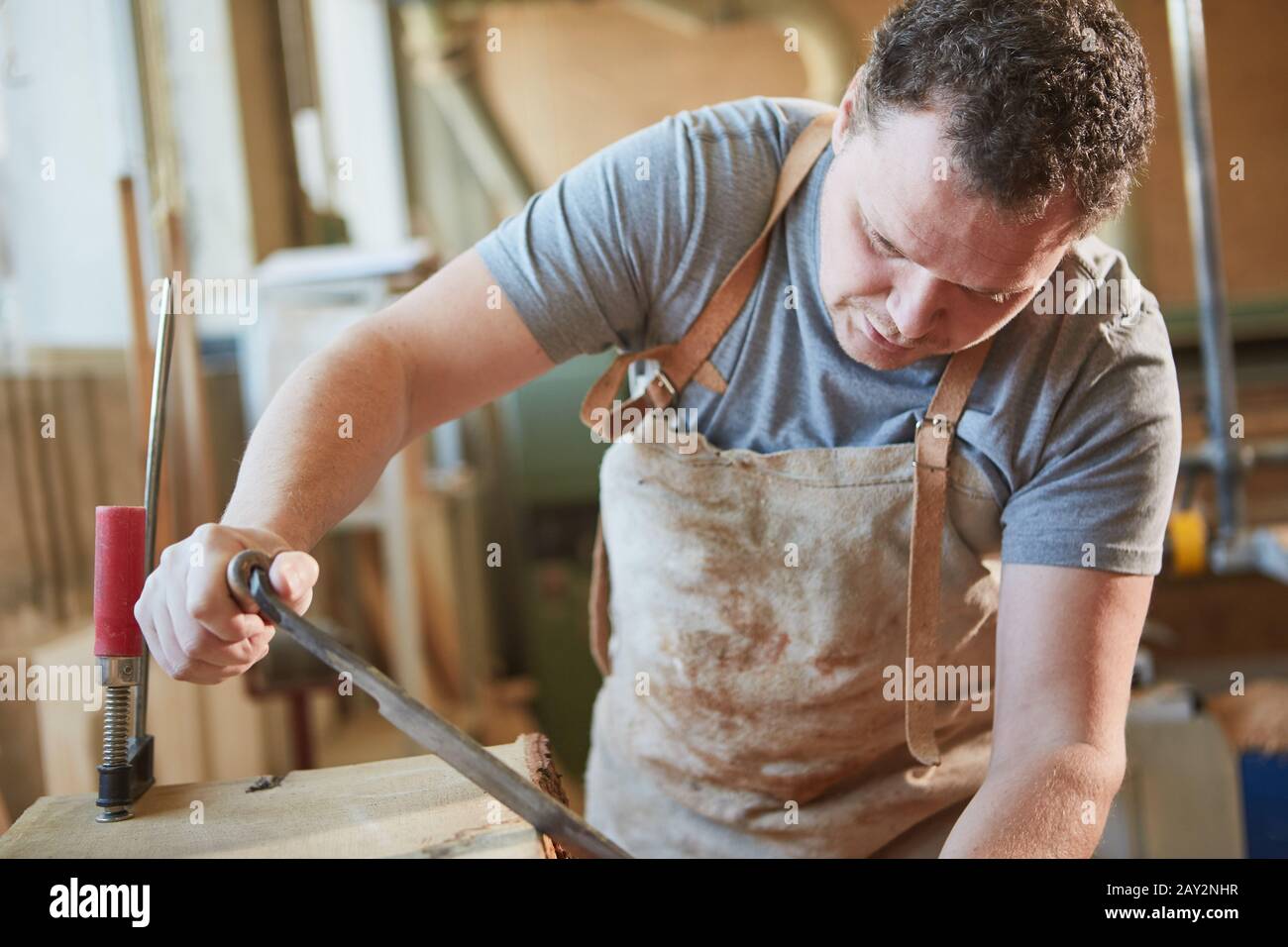 Carpenter in training when debarking wood with a pull knife or pull knife Stock Photo