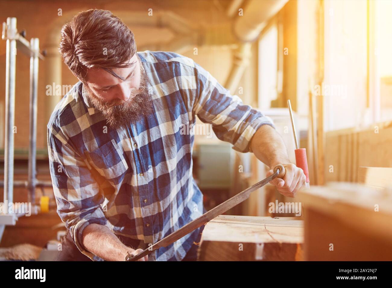 Carpenters debarking wood with peeling irons in the joinery Stock Photo
