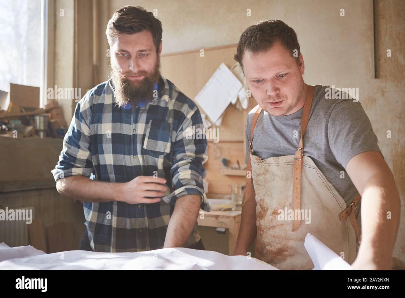 Carpenter team looks at an architectural drawing for a carpentry job Stock Photo