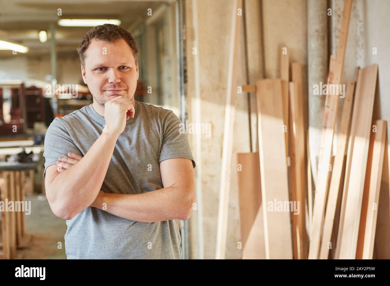 Thoughtful man as a craftsman or carpenter apprentice in a joinery Stock Photo