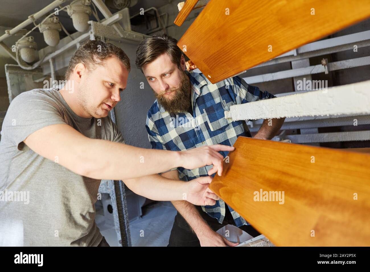 Two carpenters discuss the woodwork in the joinery together Stock Photo