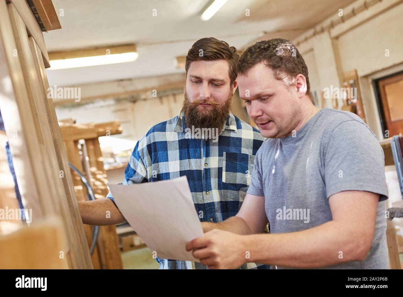 Carpenter in training with an order on paper in the joinery Stock Photo