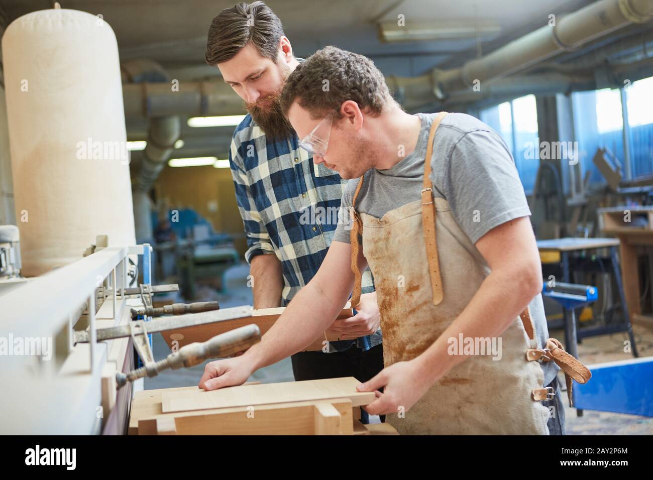 Furniture maker apprentice and trainer build a wooden shelf by hand Stock Photo
