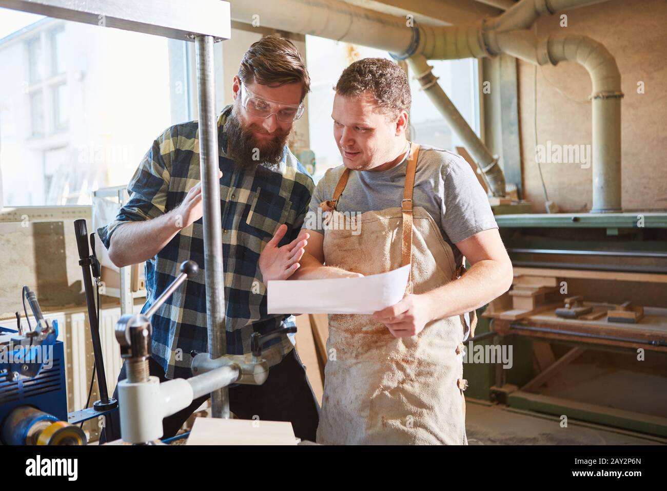 Carpenter team discusses an order on a checklist in the joinery Stock Photo