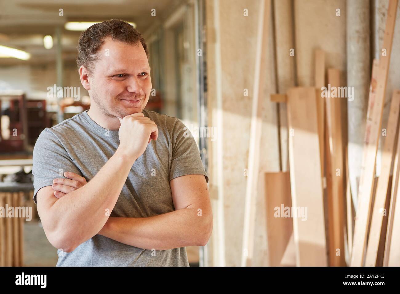 Smiling young man as a handyman in his carpentry operation Stock Photo