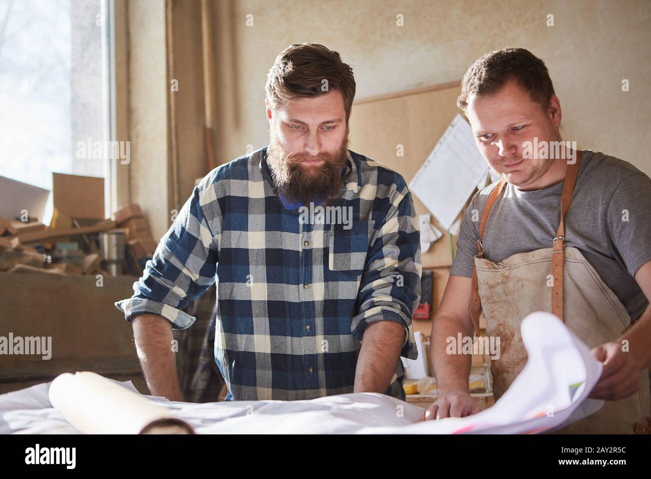 Carpenter and architect look at a construction drawing together Stock Photo