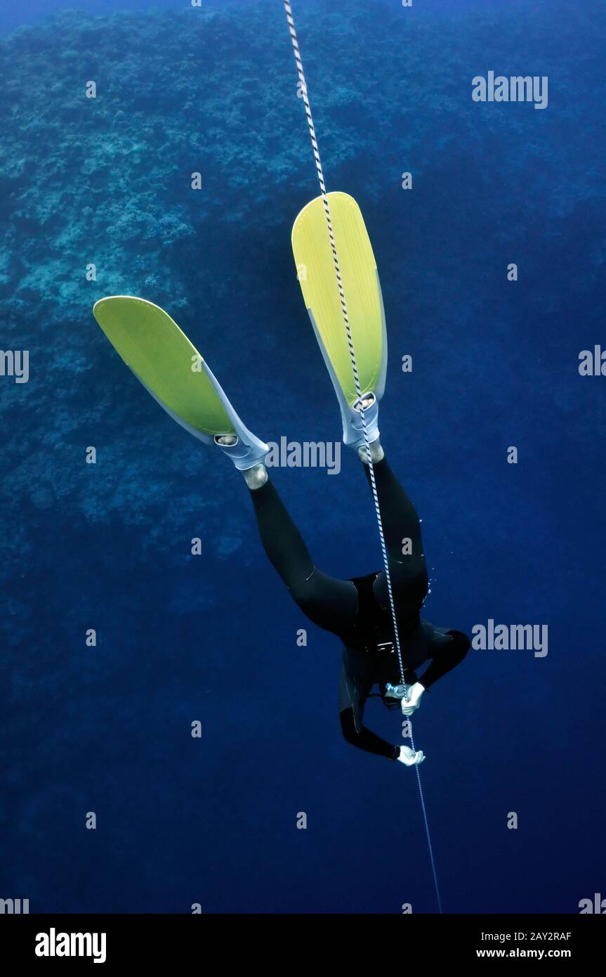Freediver in yellow fins tries to feel relaxation Stock Photo