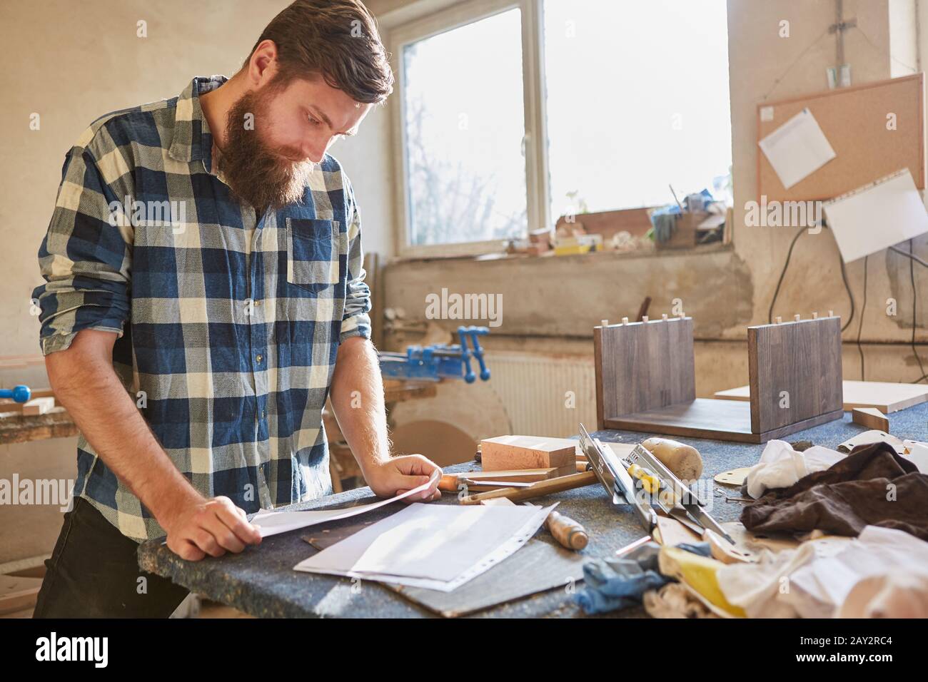 Carpenter with checklist on a piece of paper works order in the carpentry Stock Photo