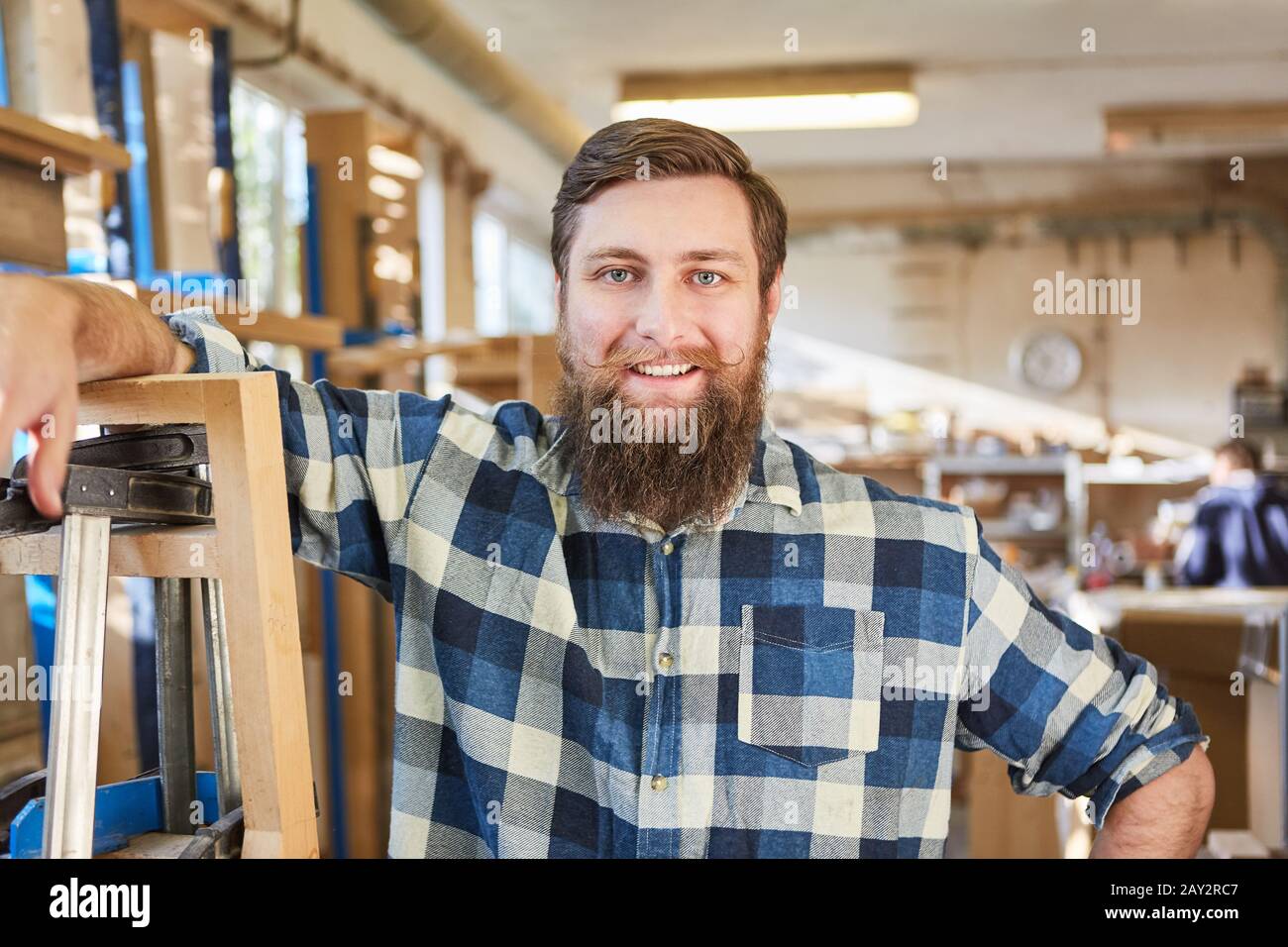 Young hipster man with a beard as a happy craftsman or founder Stock Photo