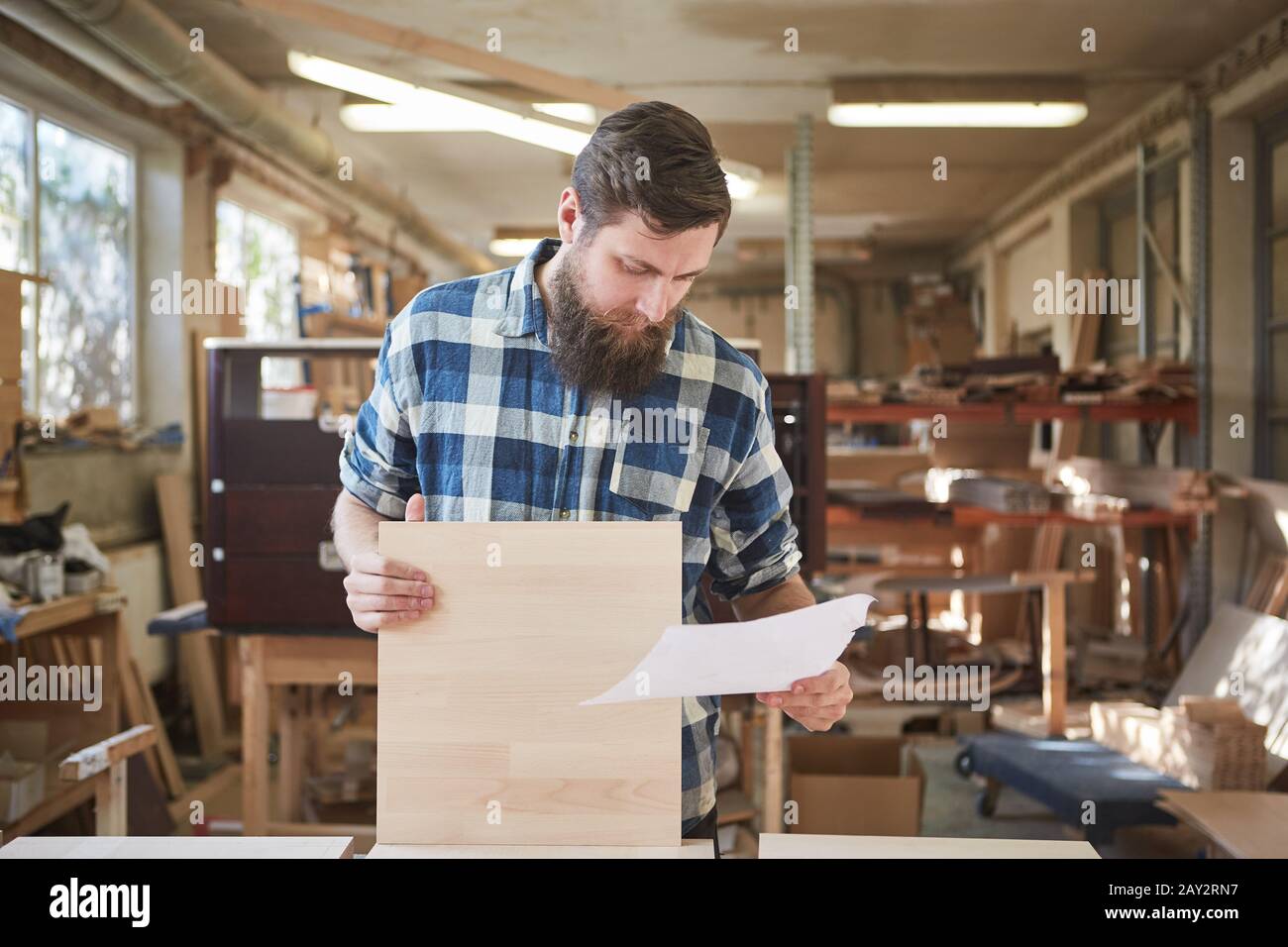 Carpenter with order on a sheet of paper in furniture making Stock Photo