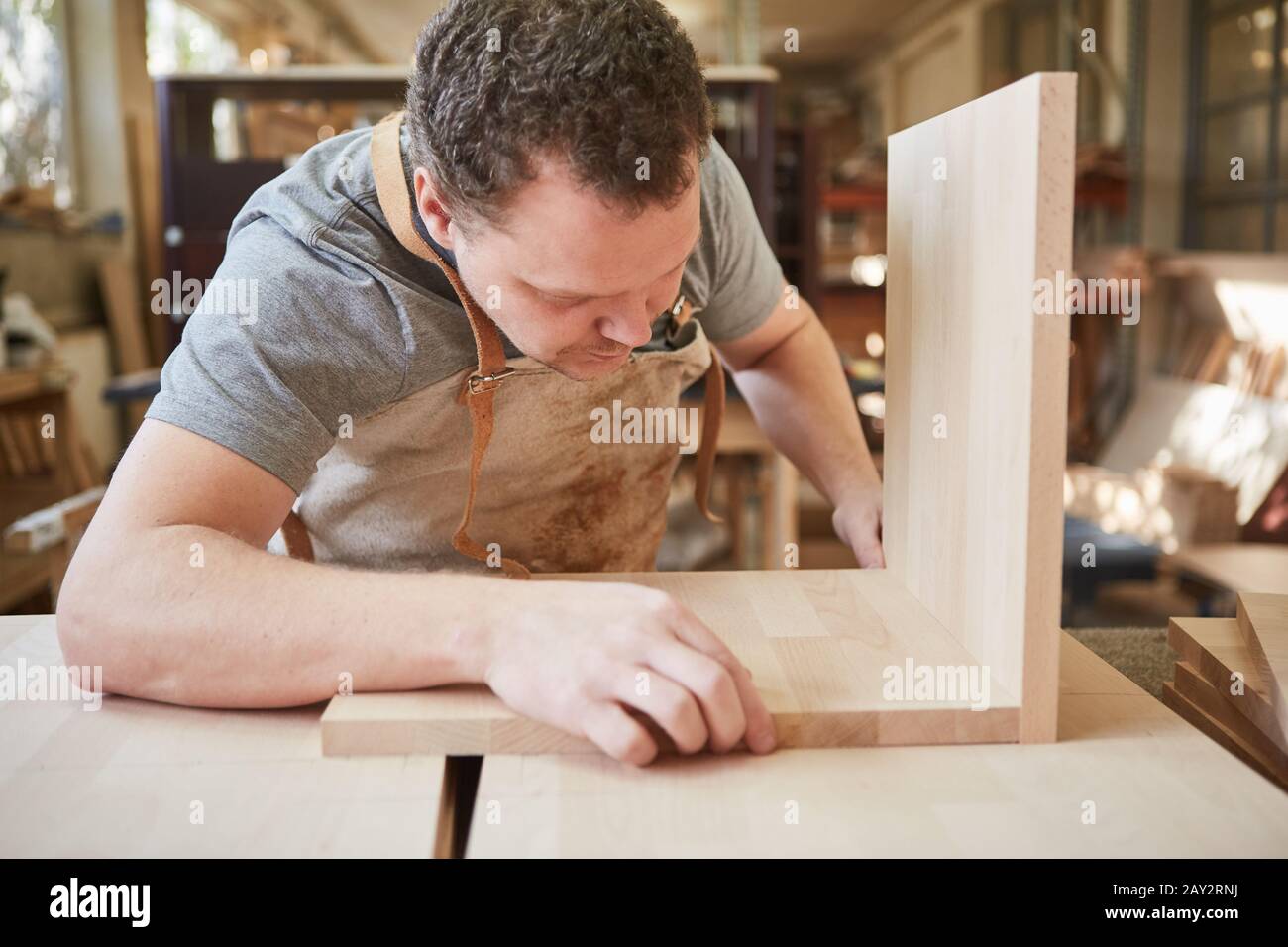 Furniture maker in training in a joinery builds a shelf from wood Stock Photo