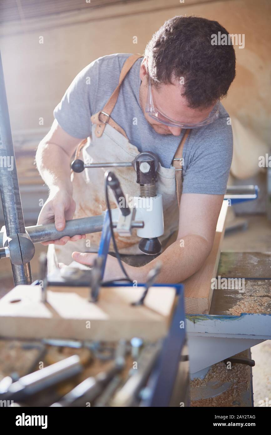 Carpenter apprentice works with wood on a staking machine Stock Photo