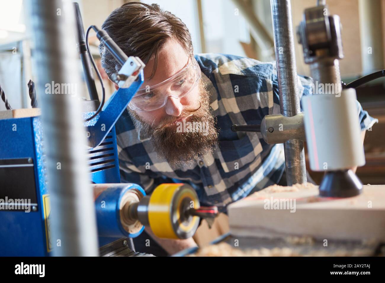 Carpenter with safety glasses when drilling wood with laser display in