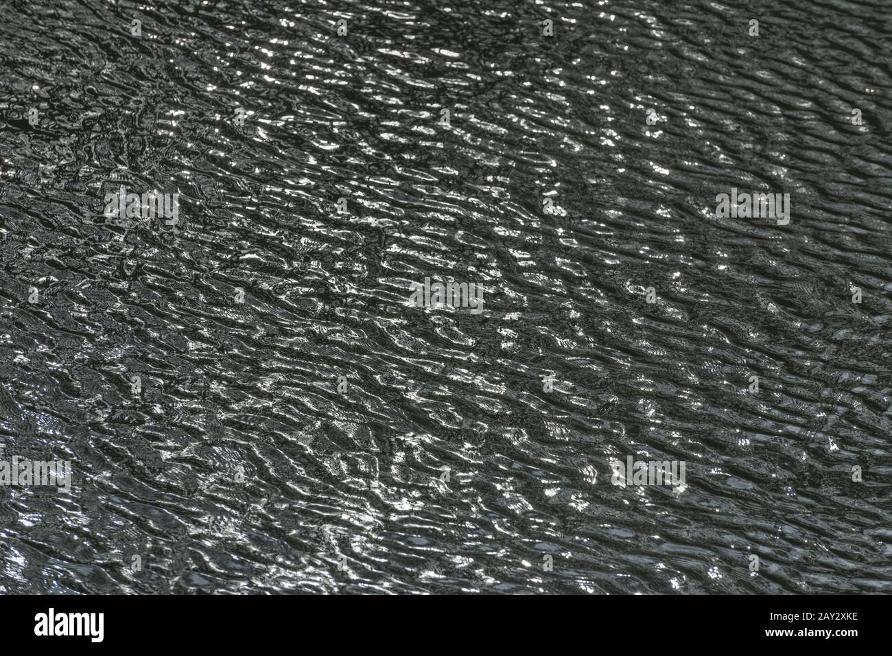 Slightly turbulent water ripples on River Fowey, Lostwithiel, Corrnwall. Metaphor breezy weather, ripple effect, water reflections, watery background. Stock Photo