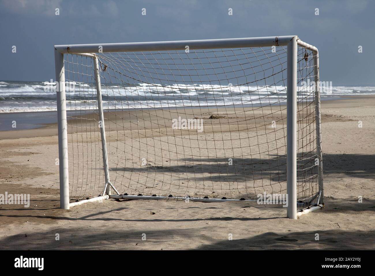 empty goal of a football or soccer playroung on the beach near the see on thesand Stock Photo