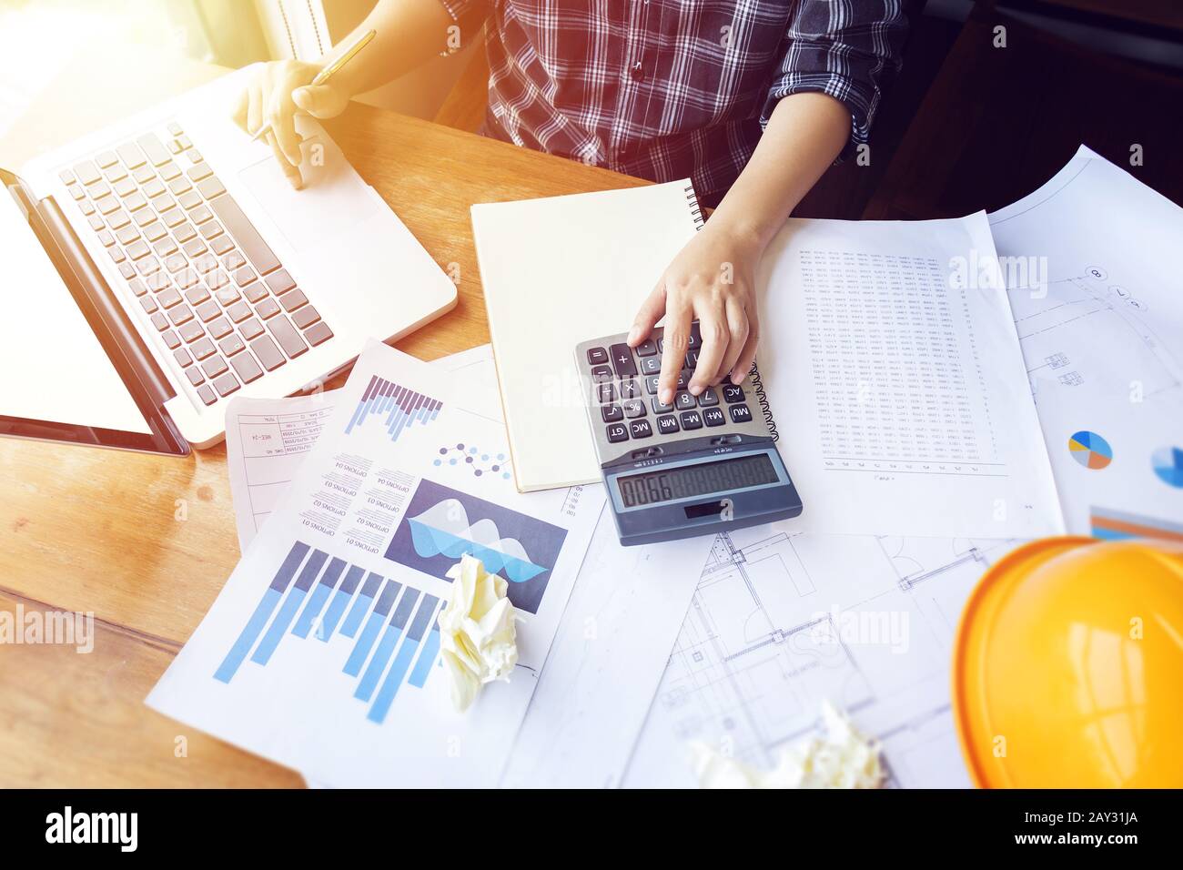 Asian business woman using calculator for accounting and analyzing investment in front of computer laptop at office work space.  banking , savings , a Stock Photo