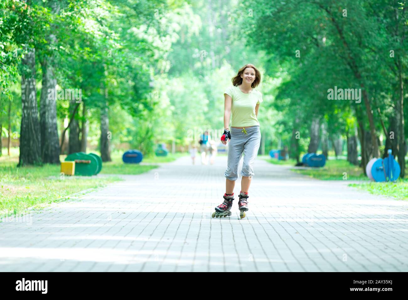 Roller skating sporty girl in park rollerblading on inline skate Stock Photo
