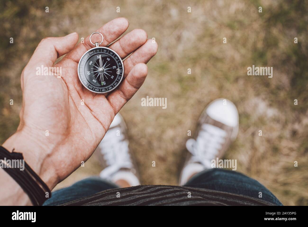 Hipster traveler holding compass in hand Stock Photo