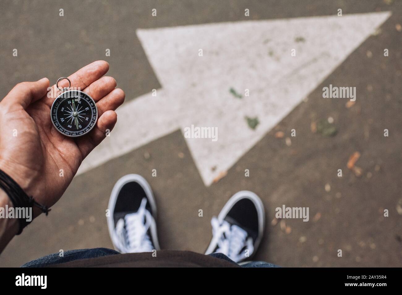 Hipster traveler holding compass in the hand making choice in what direction to go Stock Photo