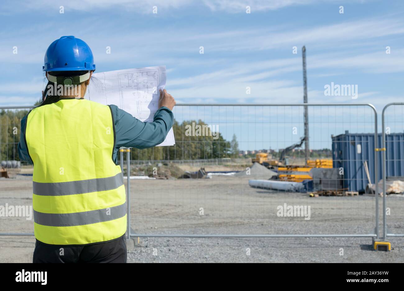 Woman holding blueprint at construction site Stock Photo - Alamy