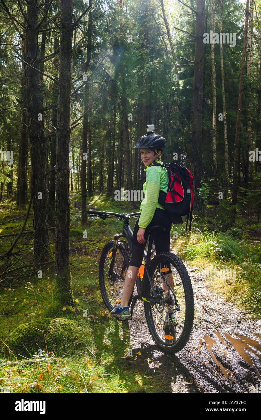 Boy cycling in forest Stock Photo