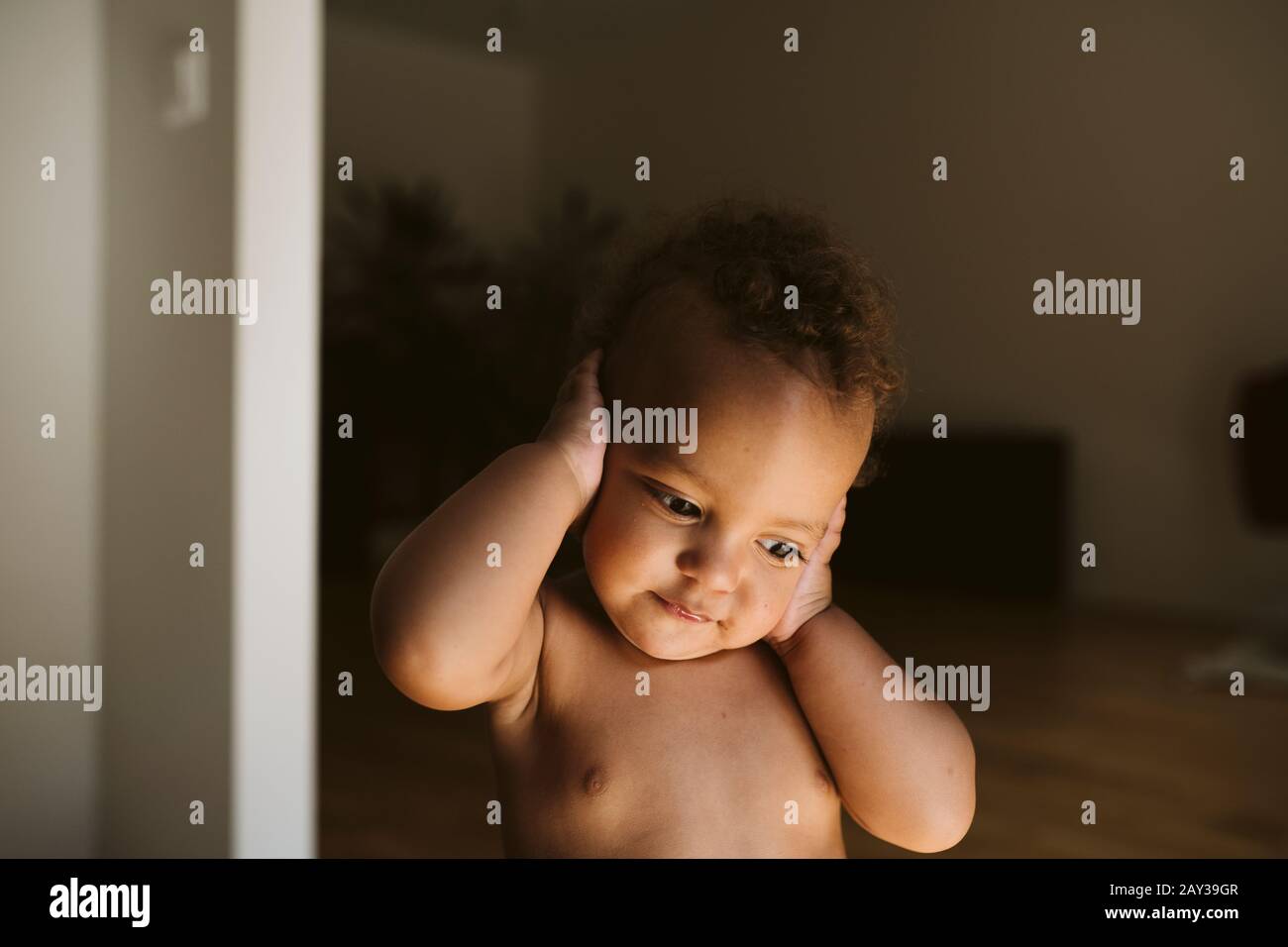 Toddler covering ears Stock Photo