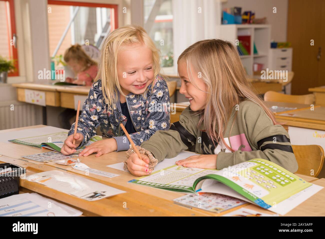 Smiling girls in classroom Stock Photo - Alamy
