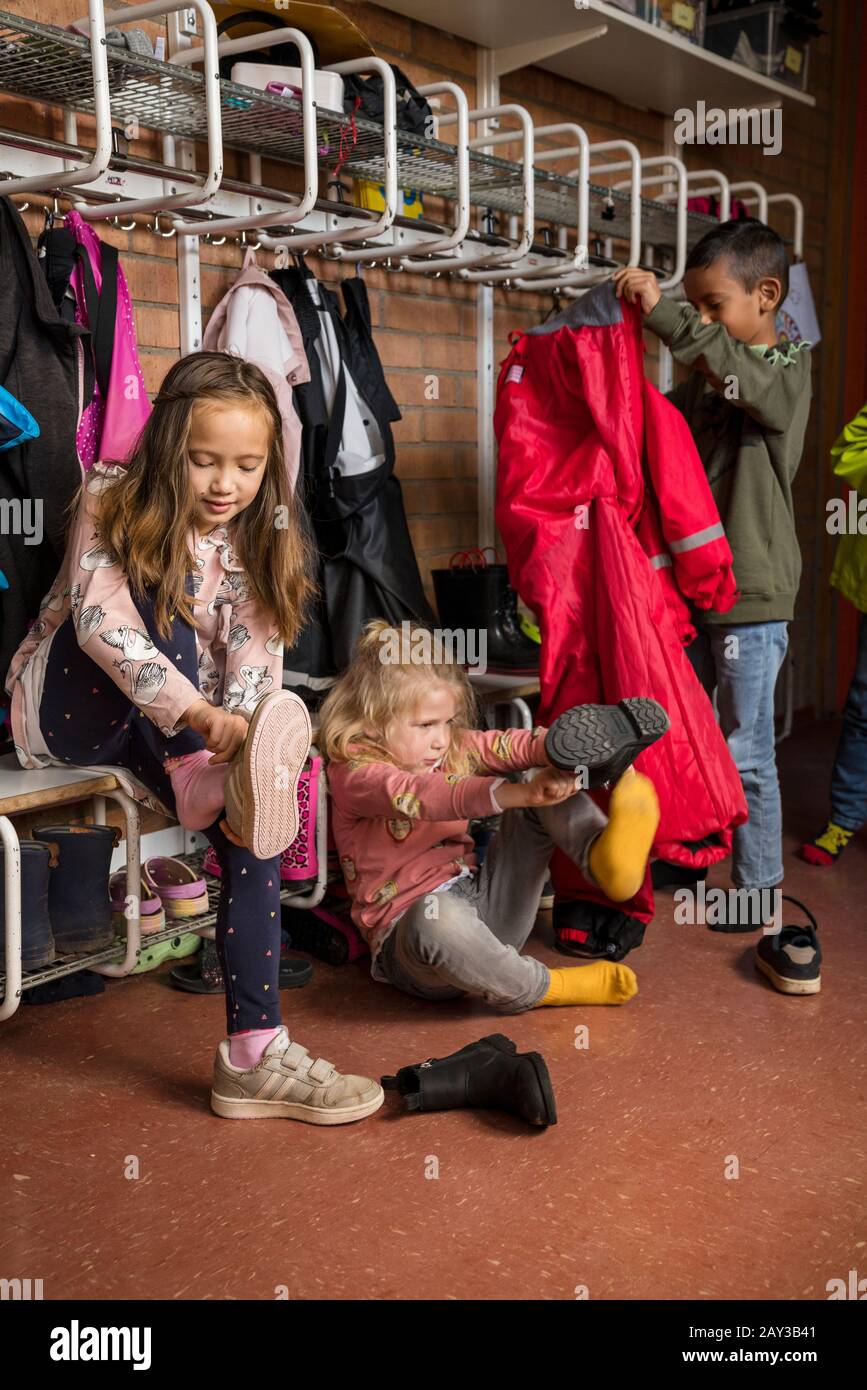 Children getting dressed at school Stock Photo