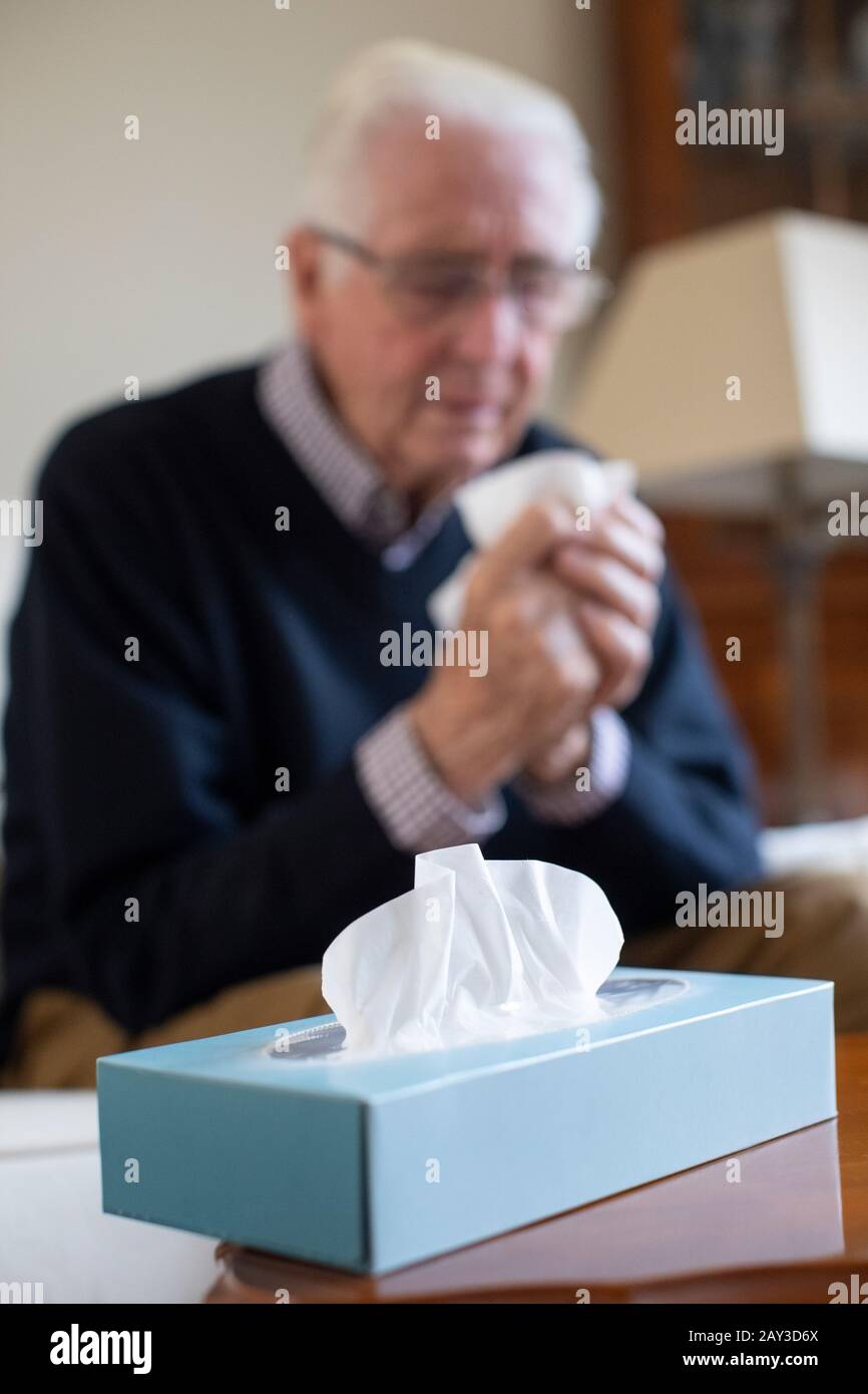 Senior Man At Home Suffering With Cold Or Flu Virus Stock Photo
