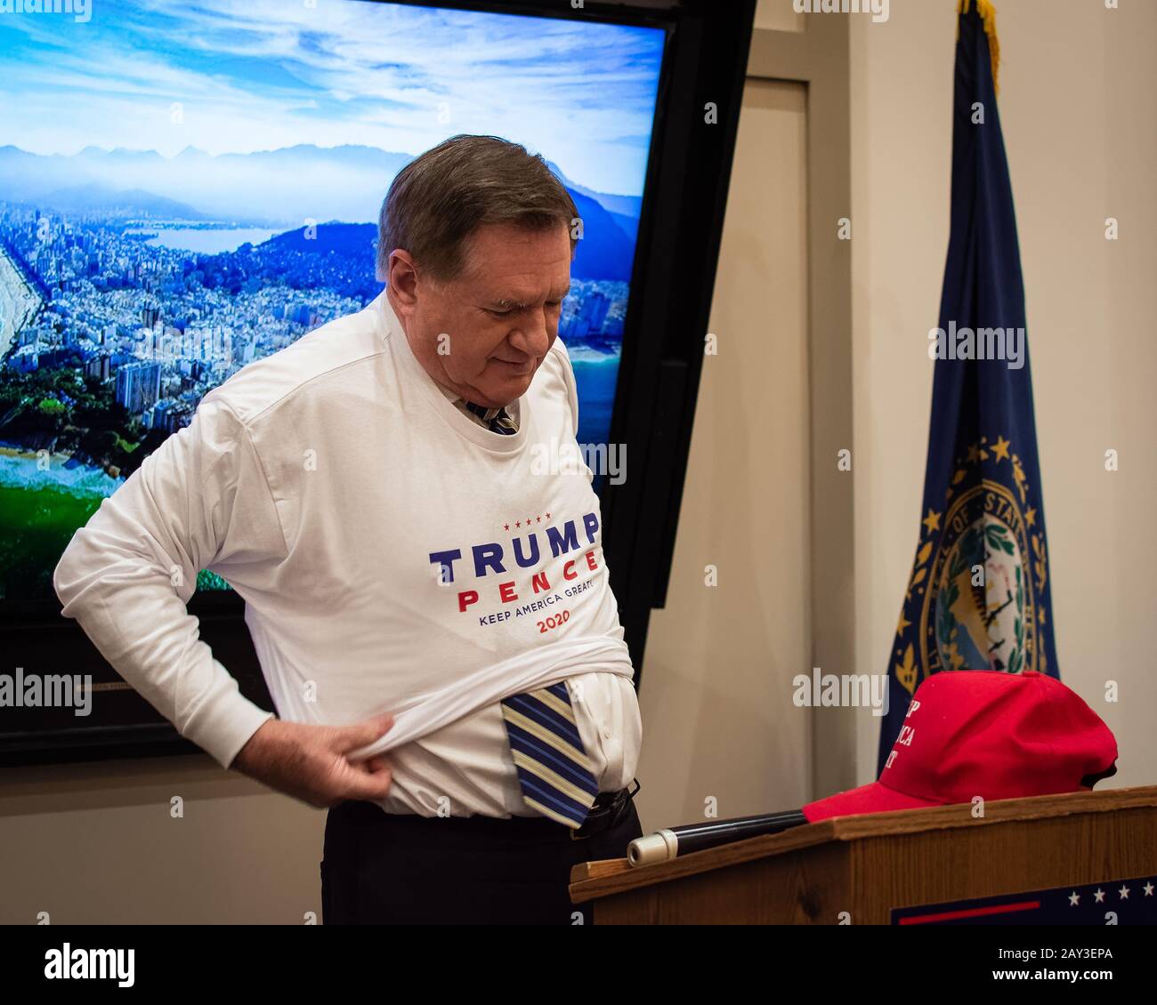 The Republican Executive Committee Chairman Stephen Stepanek puts on a Trump 'Keep America Great' t-shirt over his white shirt Stock Photo