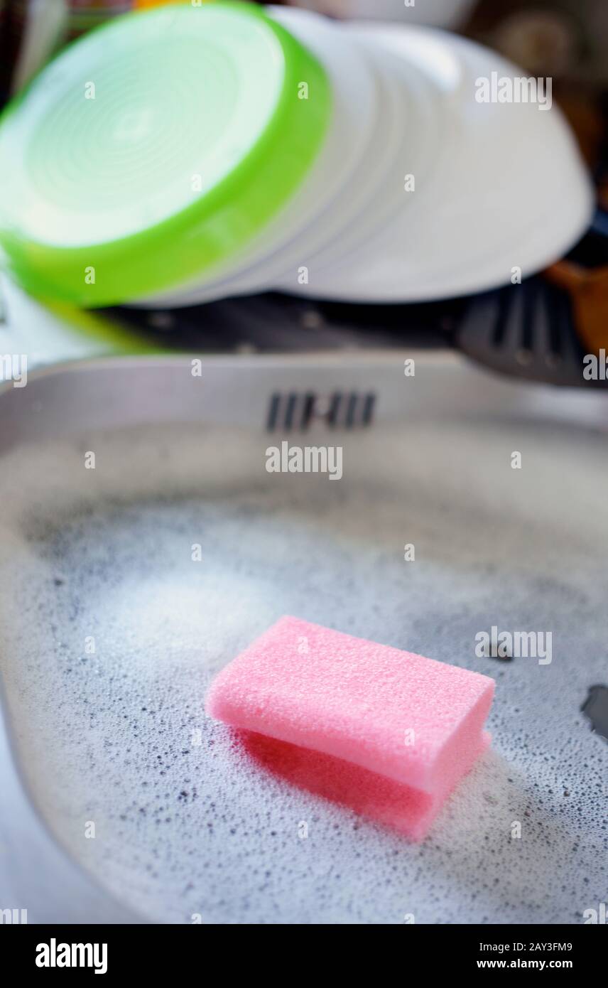 A pink sponge in the sink with clean dishes Stock Photo Alamy