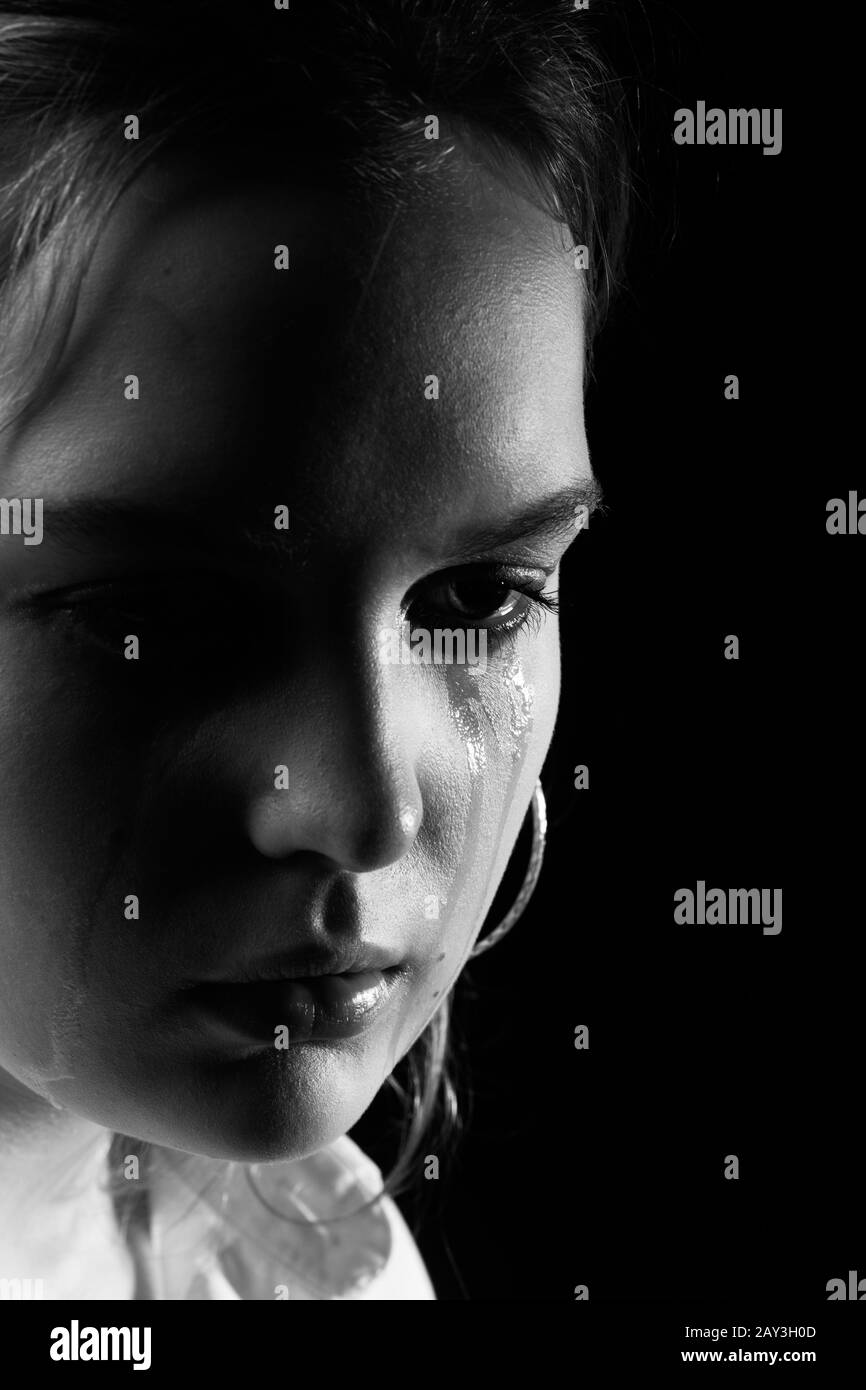 sad woman crying, looking aside on black background, closeup portrait, monochrome Stock Photo