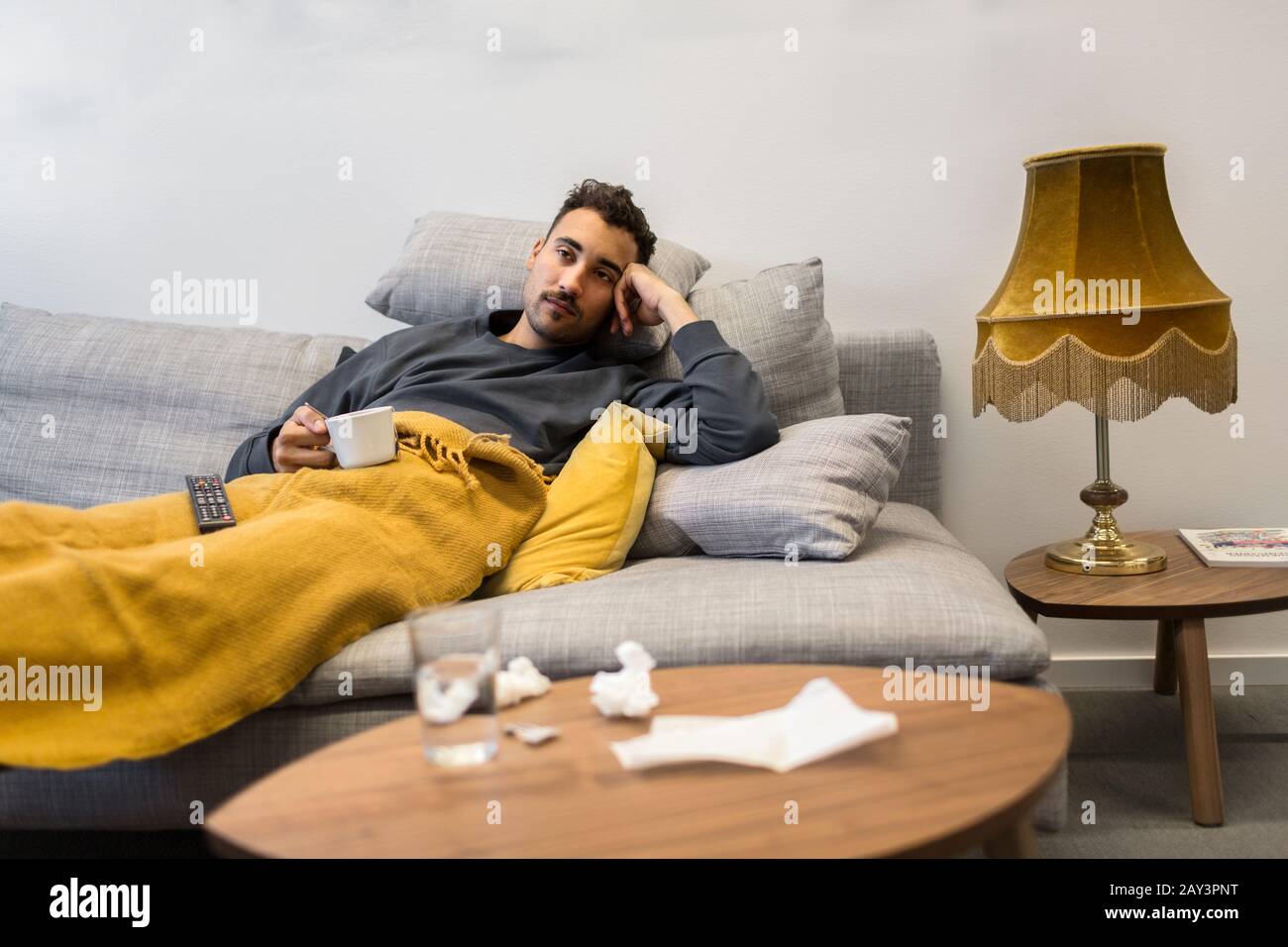 Man cold sitting on sofa hi-res stock photography and images - Alamy