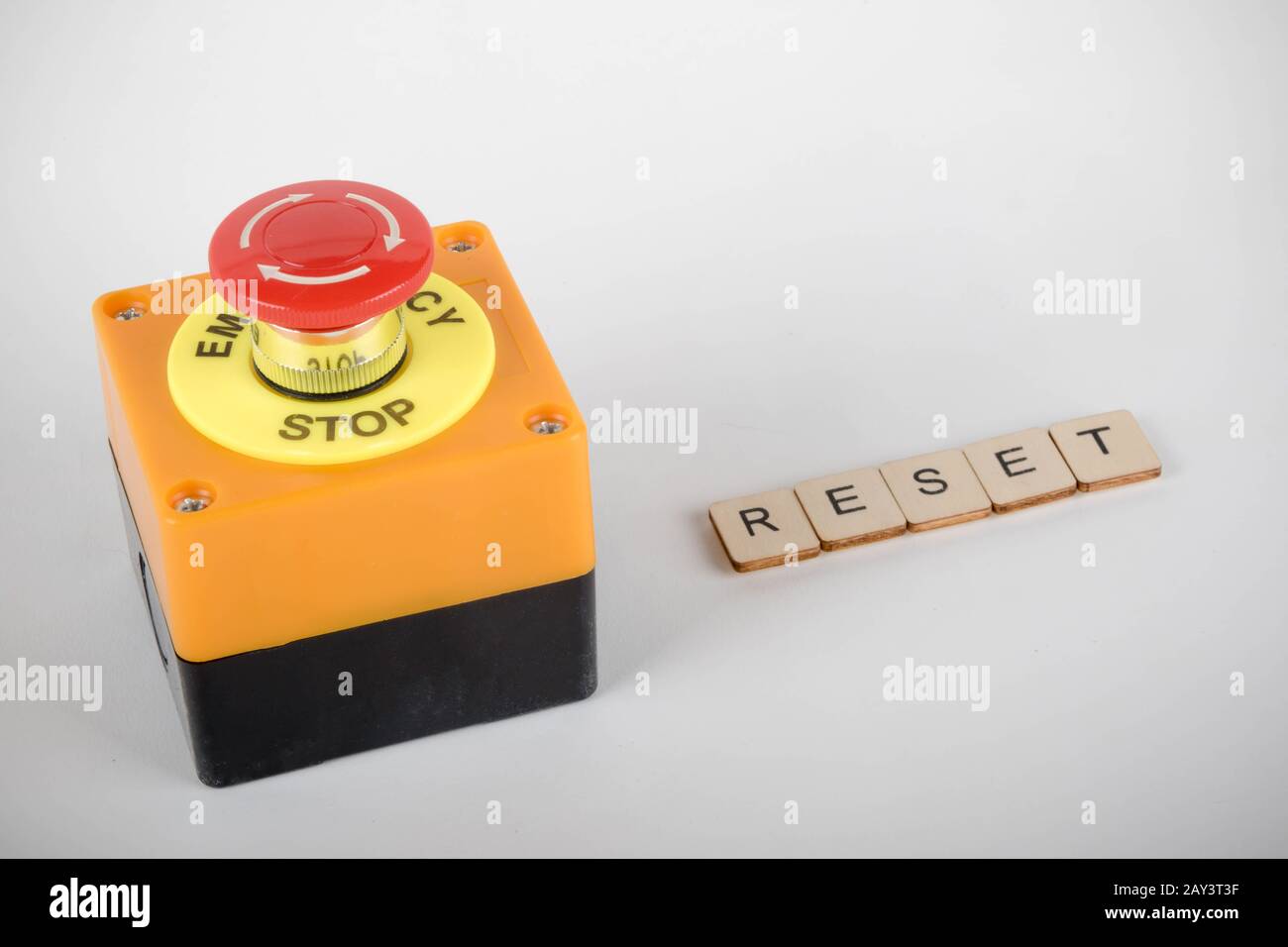 An industrial emergency stop button with a sign reading Reset Stock Photo