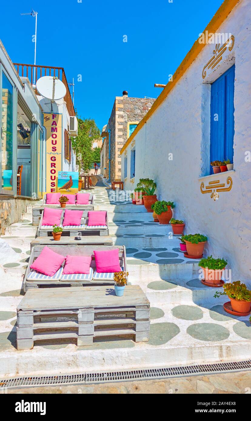 Perdika, Aegina Island, Greece  - September 14, 2019:  Open-air restaurant at with couches in the street in Perdika Stock Photo