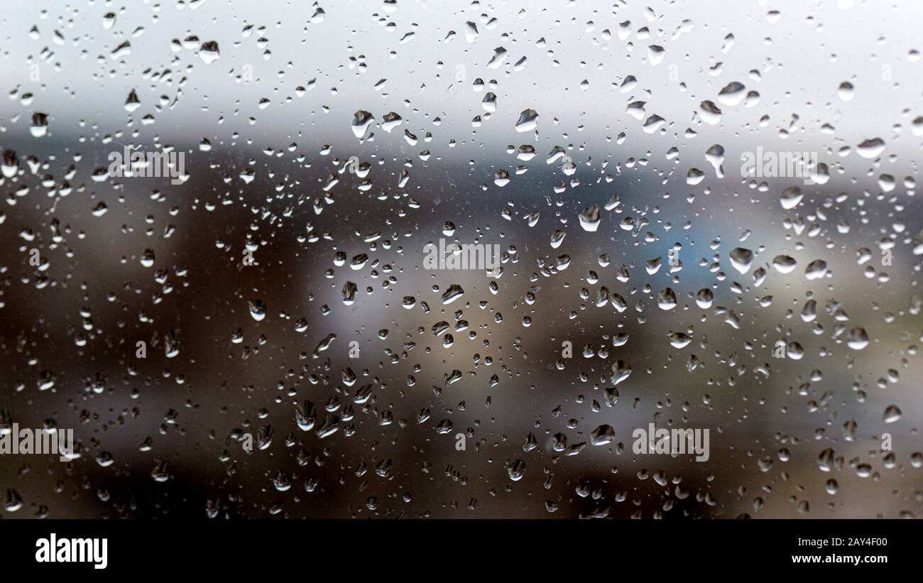 View of the city in a rainy day through a window covered with water ...