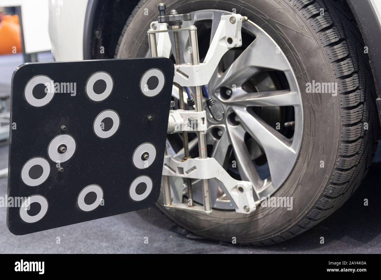 Car mechanic installing sensor during suspension adjustment and