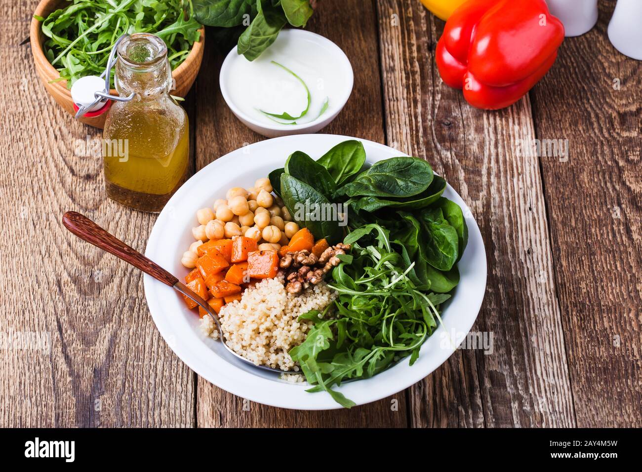 Preparing Fresh Salad With Chickpeas Spinach Arugula Quinoa Carrot Walnuts Greek Yogurt And Homemade Salad Dressing Vegetables Herbs On Rustic Stock Photo Alamy