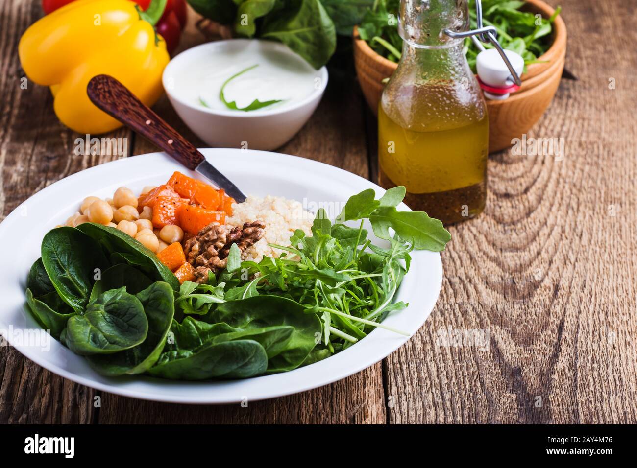 Preparing Fresh Salad With Chickpeas Spinach Arugula Quinoa Carrot Walnuts Greek Yogurt And Homemade Salad Dressing Vegetables Herbs On Rustic Stock Photo Alamy