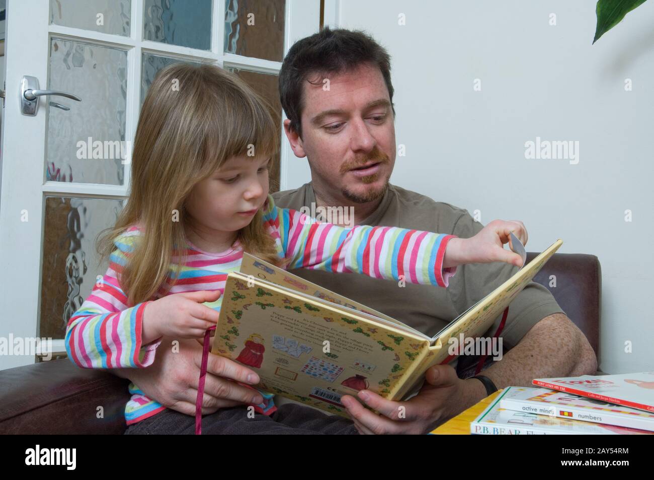 father and daughter enjoying reading together Stock Photo