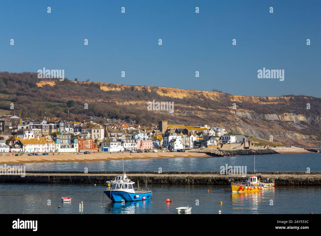 Colourful fishing boats in Lyme Regis harbour on the Jurassic Coast on a sunny day with a high winter tide, Dorset, England, UK Stock Photo