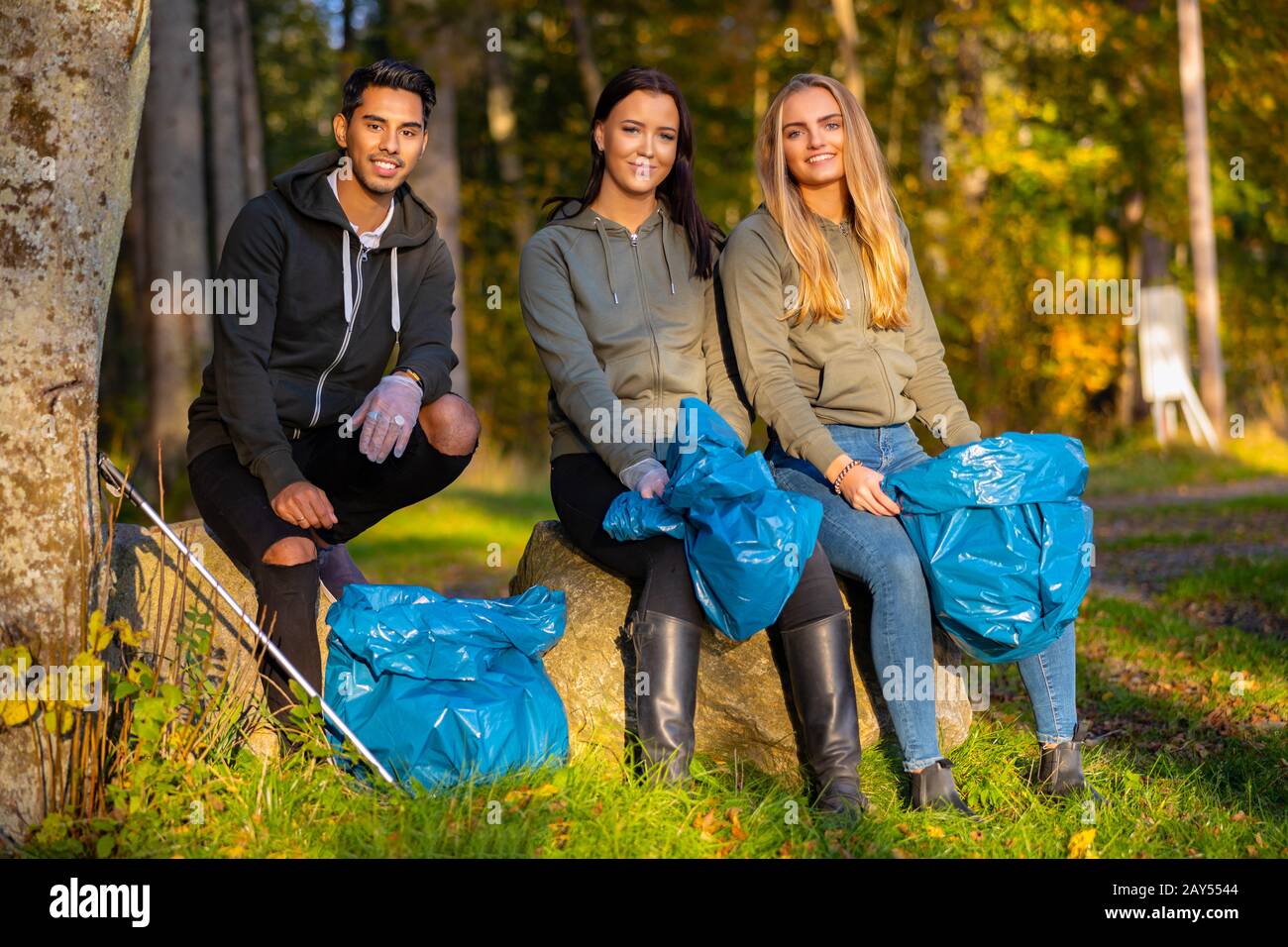 Female volunteers picking up garbage on grass Stock Photo