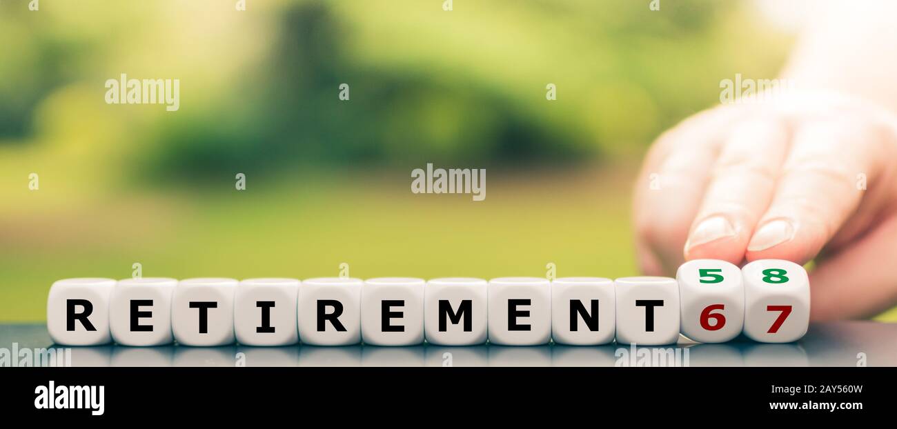 Hand turns dice and changes the expression 'retirement 67' to 'retirement 58'. Stock Photo