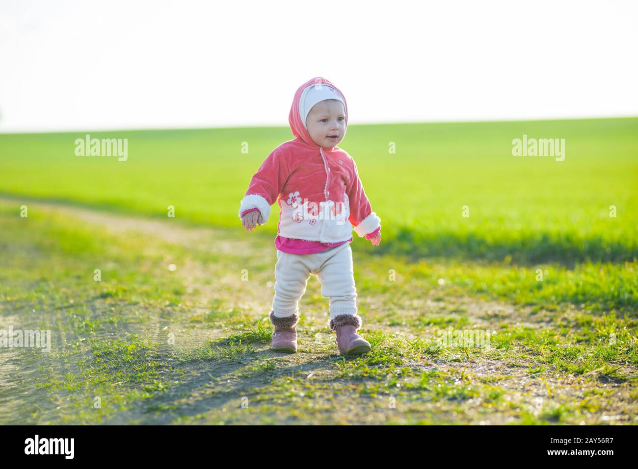 Happy little girl walking in the meadow and looking at sun Stock Photo ...